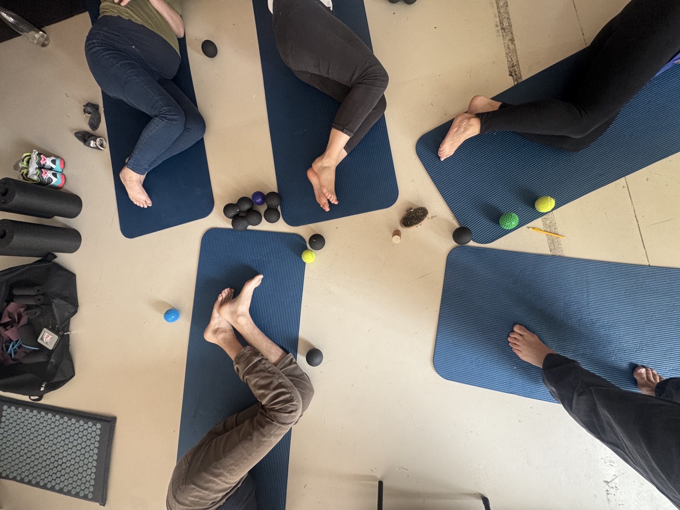 Participants allongés sur des tapis pendant un atelier d'automassage avec balles